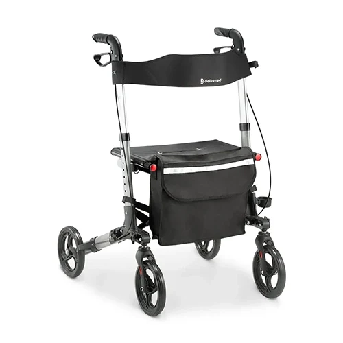 Andador de alumínio compacto com quatro rodas modelo D14 Dellamed, fotografado em ângulo de três quartos sobre fundo branco. O equipamento exibe estrutura de alumínio prata, manoplas ergonômicas com freios acoplados, faixa de encosto preta com a logomarca Dellamed, assento removível em lona escura, bolsa organizadora frontal com faixa refletiva cinza e suporte lateral para bengala ou copo.