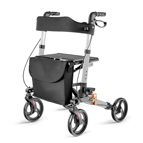 Andador ortopédico de quatro rodas modelo premium em alumínio fosco, exibido em perspectiva de três quartos sobre fundo branco. O equipamento possui manoplas ergonômicas pretas com manetes de freio integradas, assento estofado escuro com encosto em faixa flexível, bolsa de lona preta para objetos posicionada na parte frontal e rodas robustas com calotas estilizadas.