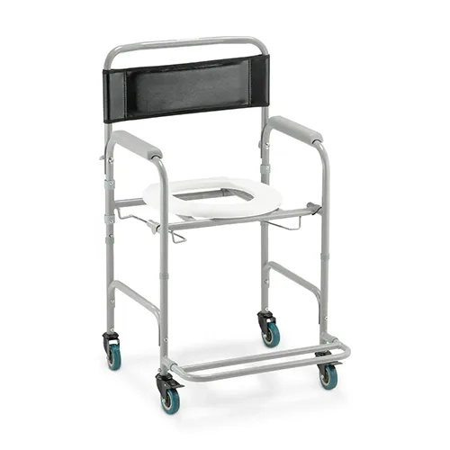 Cadeira de banho e sanitária Dellamed D30 com chassi cinza em aço carbono, exibida em perspectiva diagonal sobre um fundo branco. O modelo possui encosto em corino preto com almofada de apoio, protetores de braço cinzas, assento sanitário oval branco com abertura, suporte inferior de trilho para comadre e quatro rodízios, sendo os frontais equipados com travas duplas.