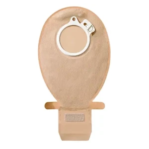 Foto centralizada sobre fundo branco da bolsa coletora opaca e drenável SenSura Click da Coloplast em tamanho Maxi. O corpo anatômico em formato oval é revestido por um tecido tecnológico não tecido na cor bege. Na porção superior da bolsa, observa-se o flange de acople mecânico circular feito de plástico branco com diâmetro de 70mm, contendo uma trava de segurança acoplada na lateral superior direita. O design estende-se inferiormente para um canal de escoamento equipado com abas estabilizadoras laterais e uma área com fecho de velcro integrado para vedação segura da abertura.