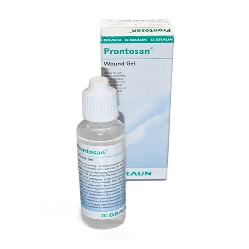 Frasco gotejador cilíndrico e transparente do hidrogel Prontosan Gel de 30 ml com tampa cônica branca, posicionado à frente de sua embalagem retangular de papelão cartucho nas cores branca, azul claro e verde da marca B. Braun, dispostos verticalmente sobre um fundo branco liso. O rótulo e a caixa apresentam descrições técnicas em múltiplos idiomas destacando sua aplicação como gel de limpeza de feridas.